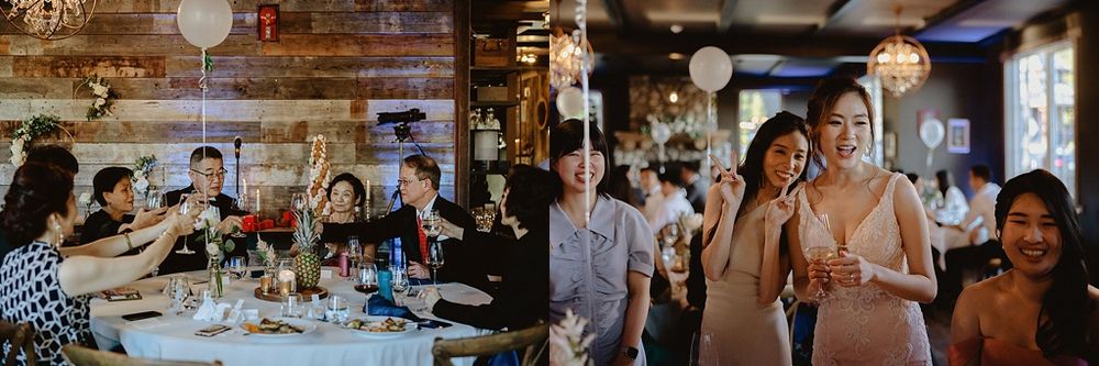 Wedding guests celebrate at long dining tables in a warmly lit rustic venue.