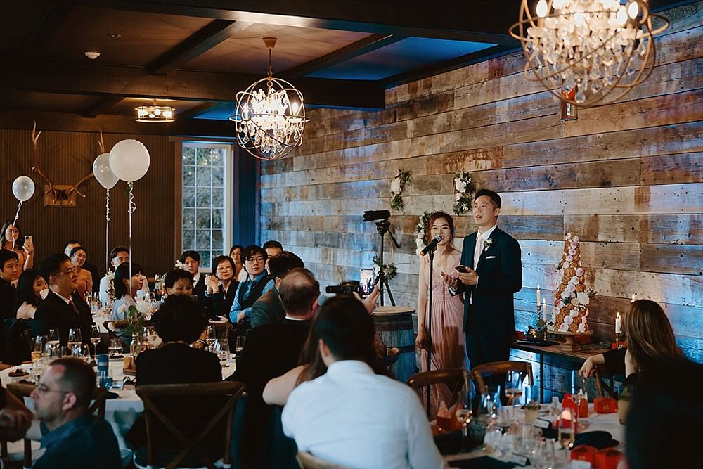 Panoramic view of wedding celebration in rustic venue with brick walls and elegant lighting.