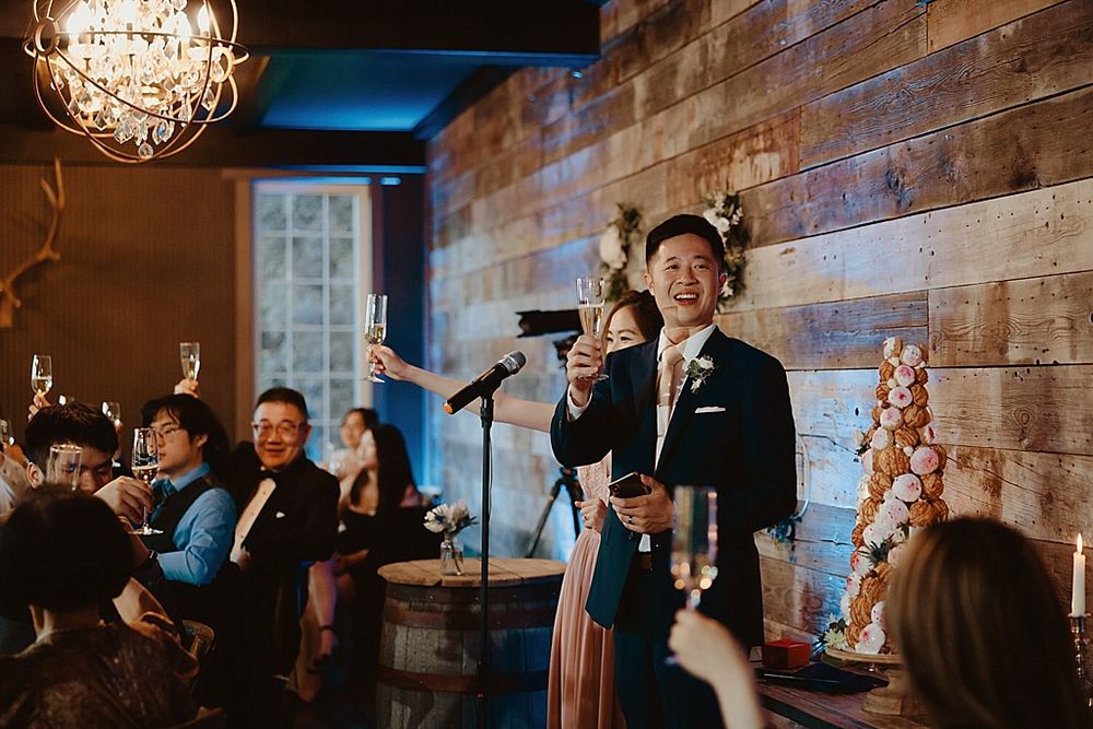Celebration moments captured in rustic-modern venue with brick walls and hanging crystal lights.