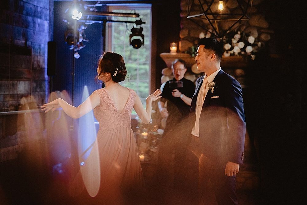 Intimate dance scene in a rustic brick-walled venue with blue mood lighting.