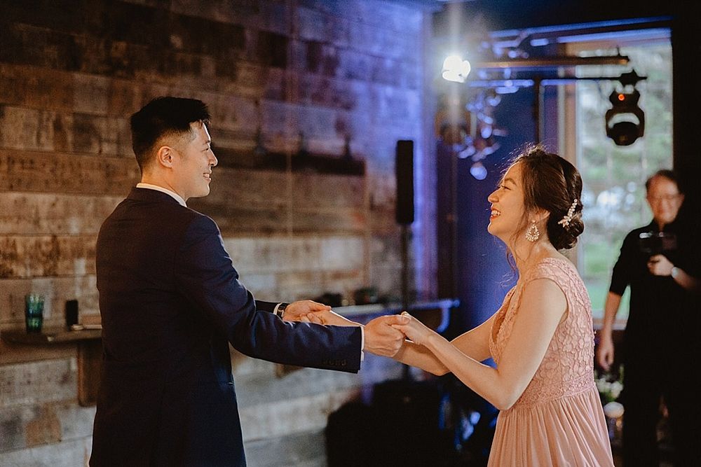 Couple sharing an intimate dance moment in an industrial-style venue with exposed brick walls.