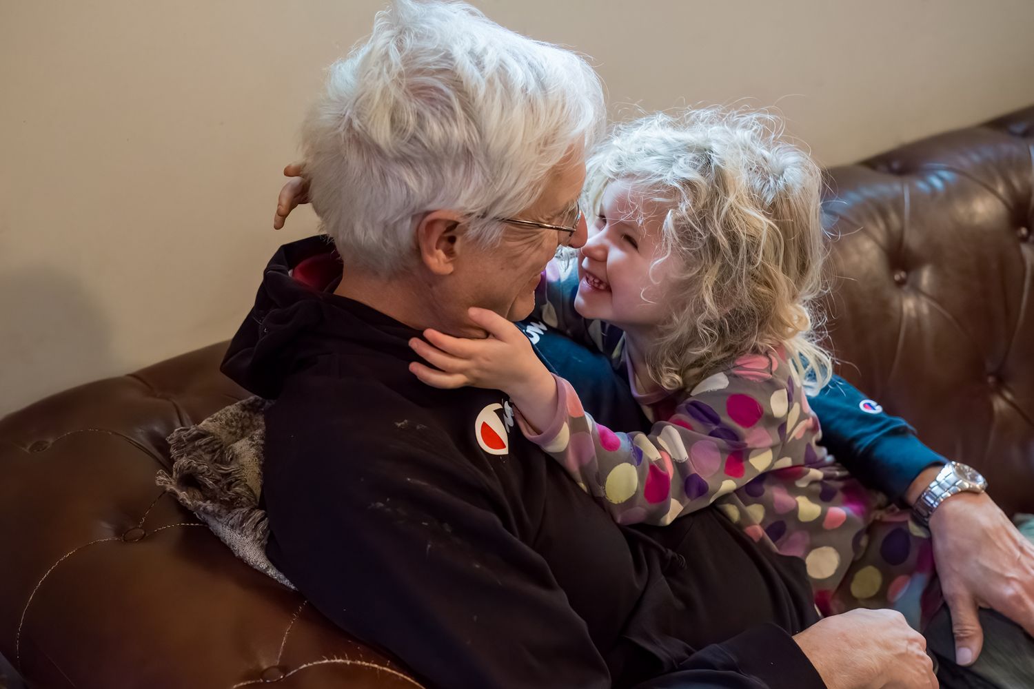 grandfather and granddaughter laughing on the couch