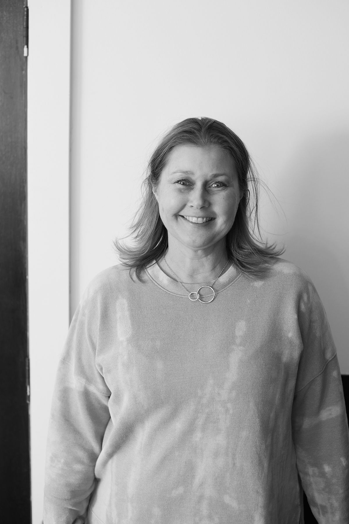 Portrait series showing natural smiles wearing light colored sweater against white background.