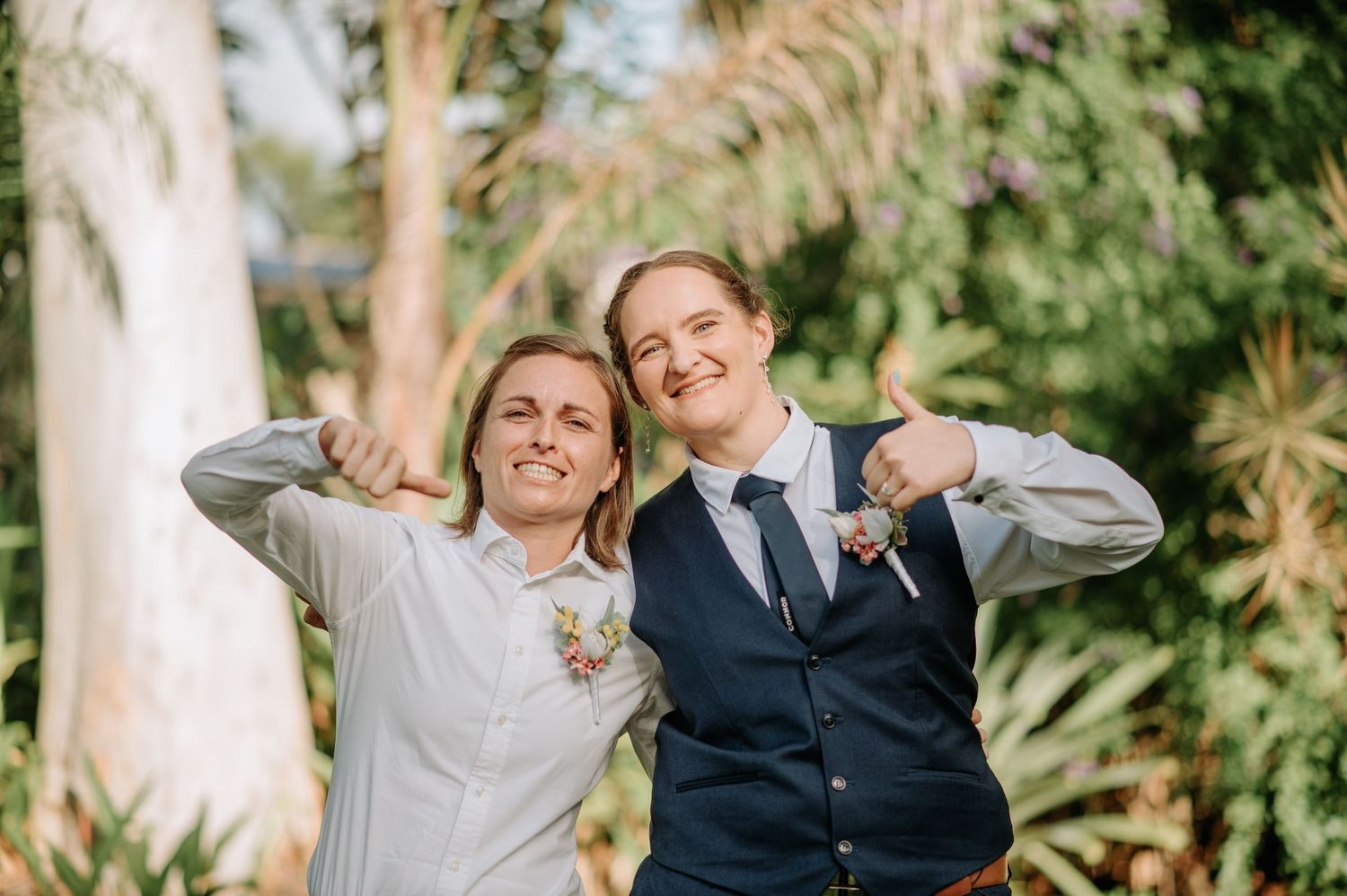 A playful celebration moment captured in a tropical garden setting with palm trees.