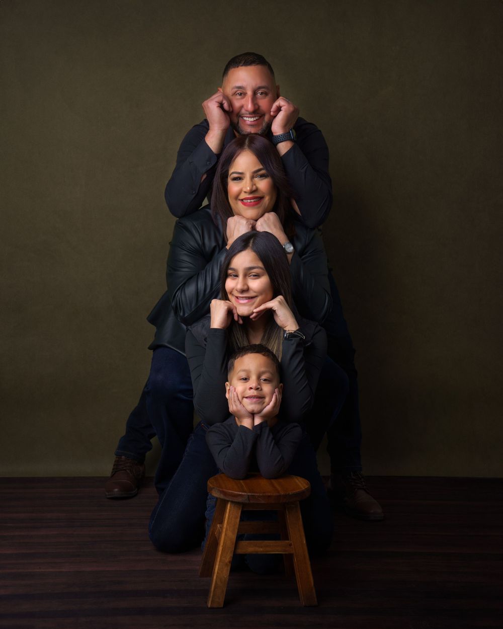 Fun studio portrait session with playful poses against dark backdrop.