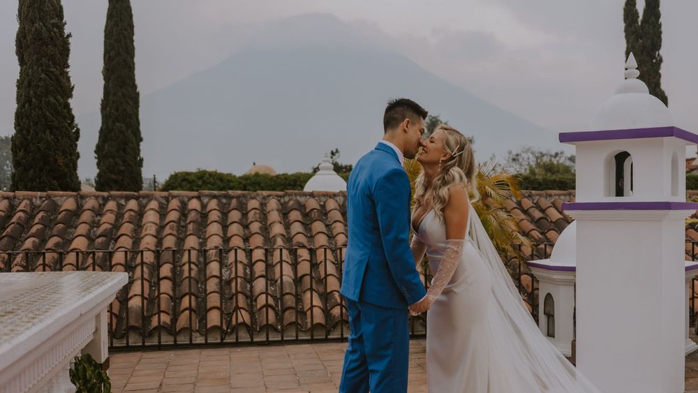 Intimate wedding moment shared on a terrace with terra cotta roofs and cypress trees in background.