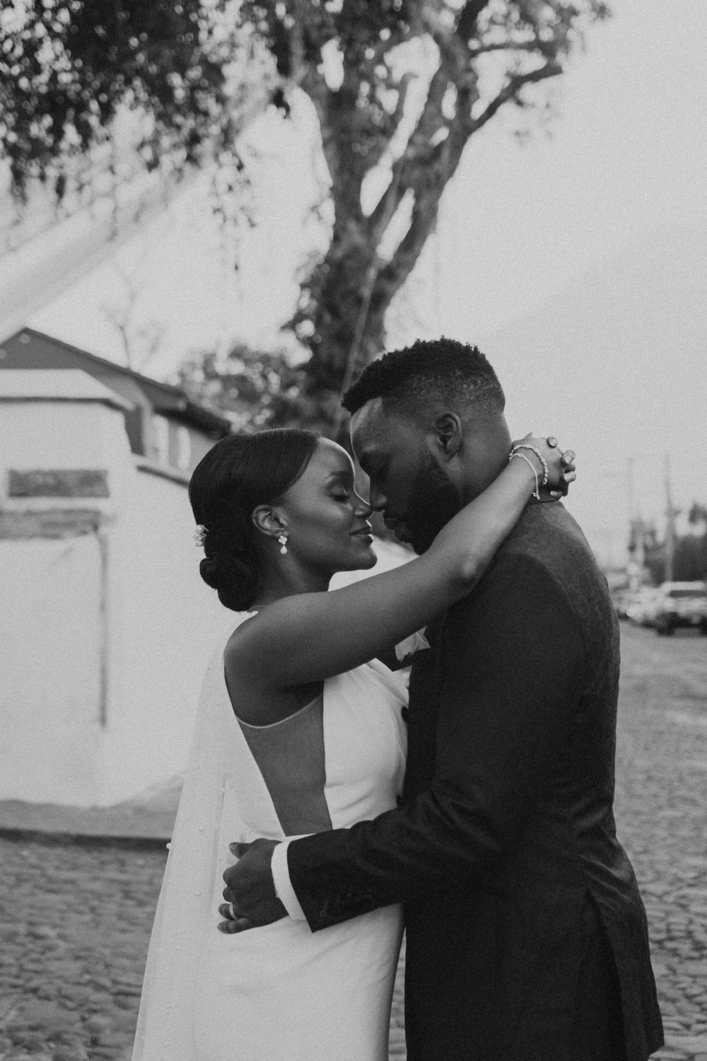 Black and white intimate portrait of newlyweds embracing outdoors.