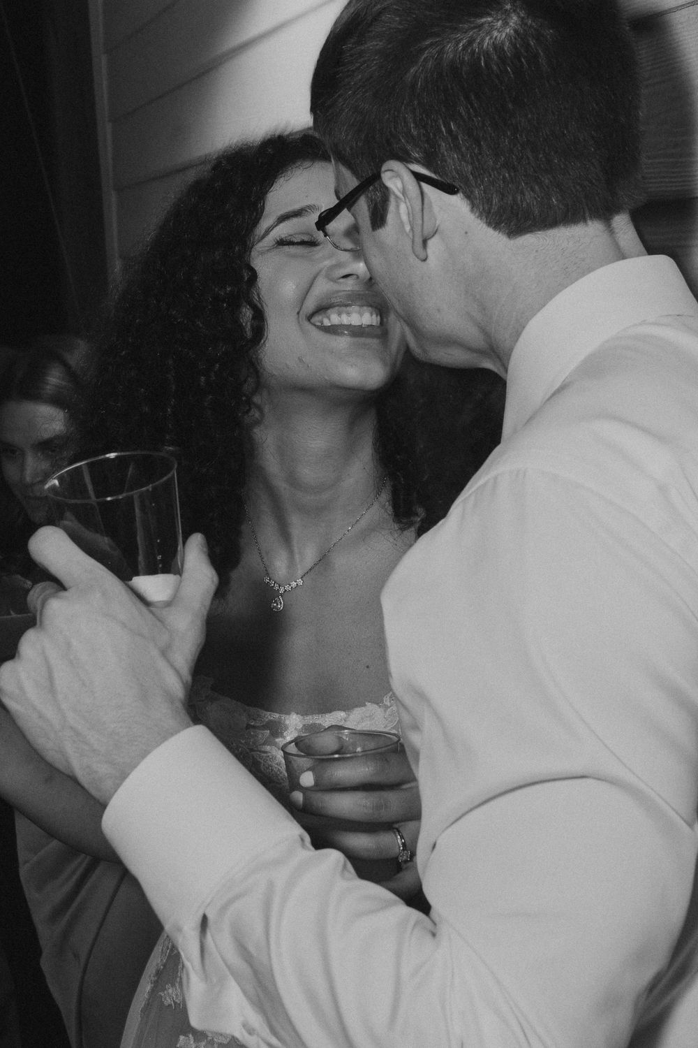 A couple shares a joyful moment while dancing together at a celebration.