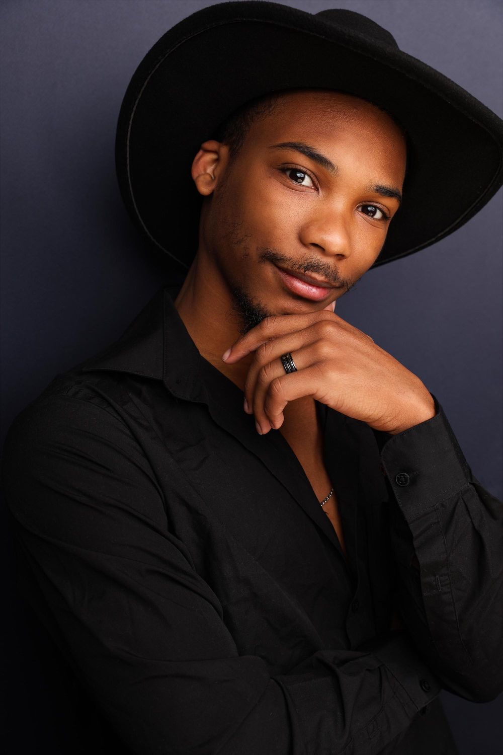 A series of artistic black and white portraits showing a person in a black shirt and hat against a dark background.