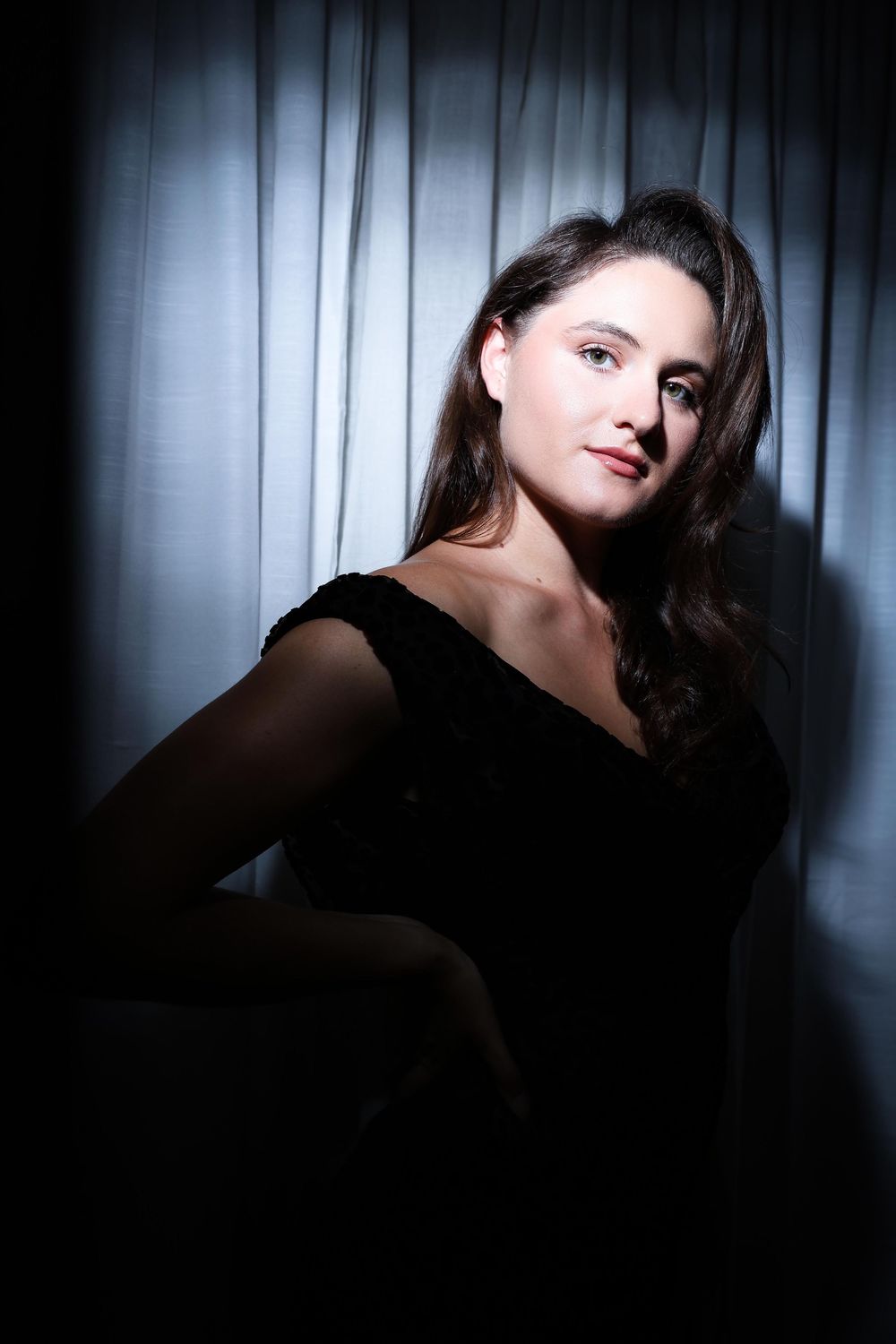 A dramatic portrait series in dark lighting shows a figure in black against venetian blinds creating moody shadows.