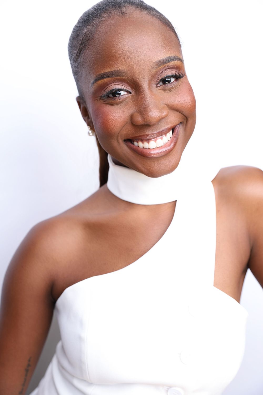Close-up beauty portraits of a woman with glowing skin and bright smile against white background.