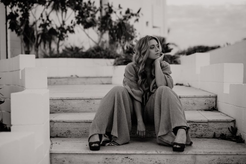 Monochromatic photo series of someone lounging casually on outdoor steps.