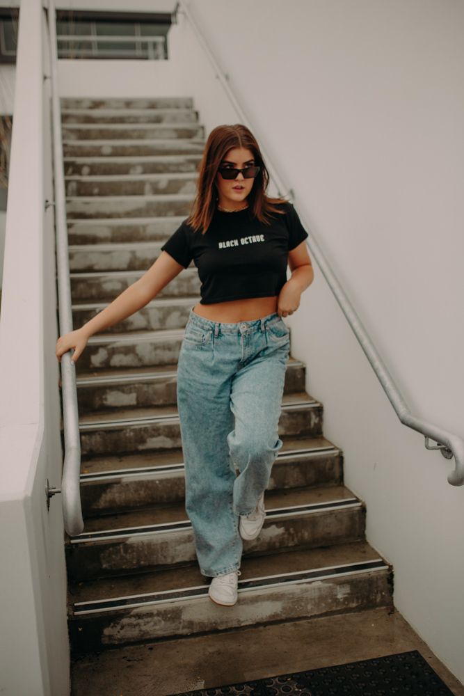 Urban fashion photography on concrete stairs with casual streetwear and sunglasses.