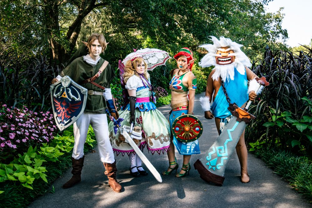 A group of Legend of Zelda cosplayers posing together on a garden path.