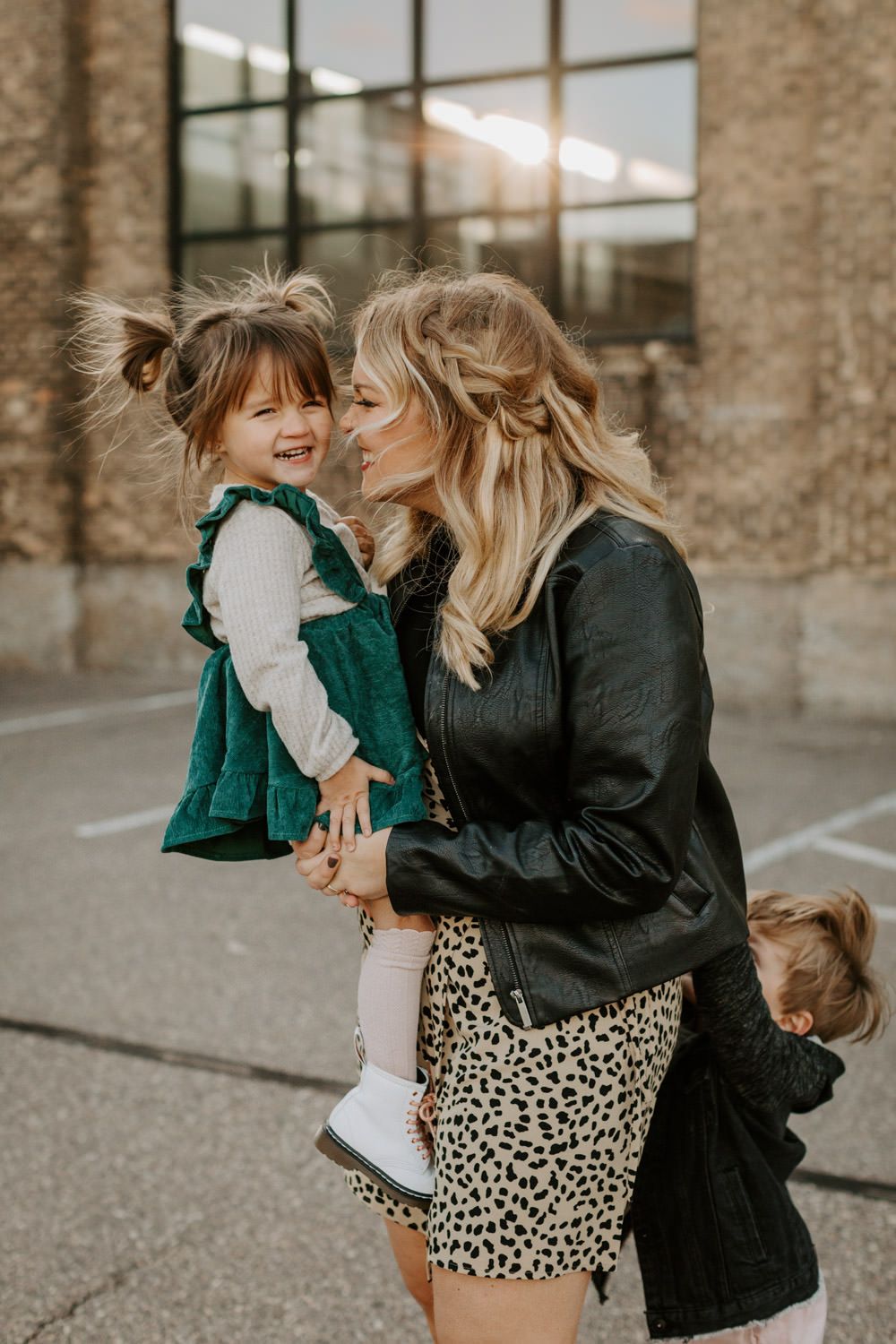 A heartwarming moment between two figures in an urban setting with brick walls and natural lighting.