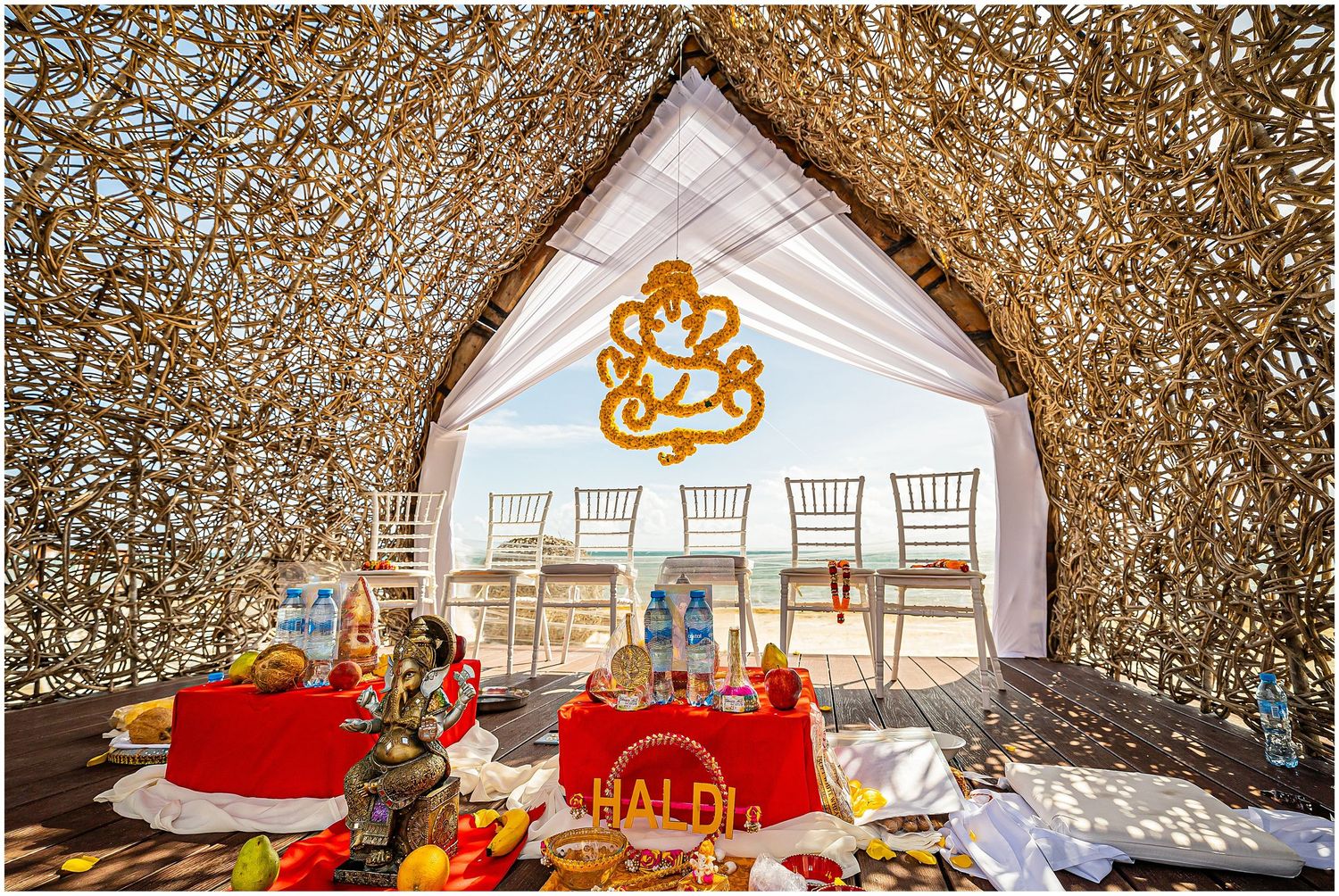 Wedding ceremony space with golden Ganesh symbol and traditional Indian decor elements.