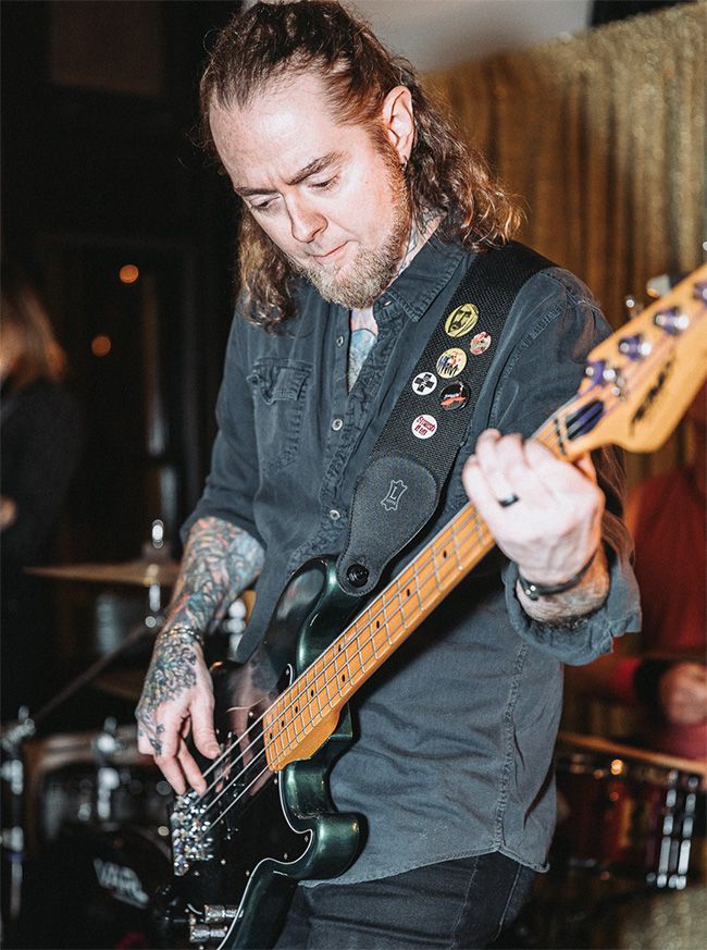 Man playing bass guitar on a stage during a concert