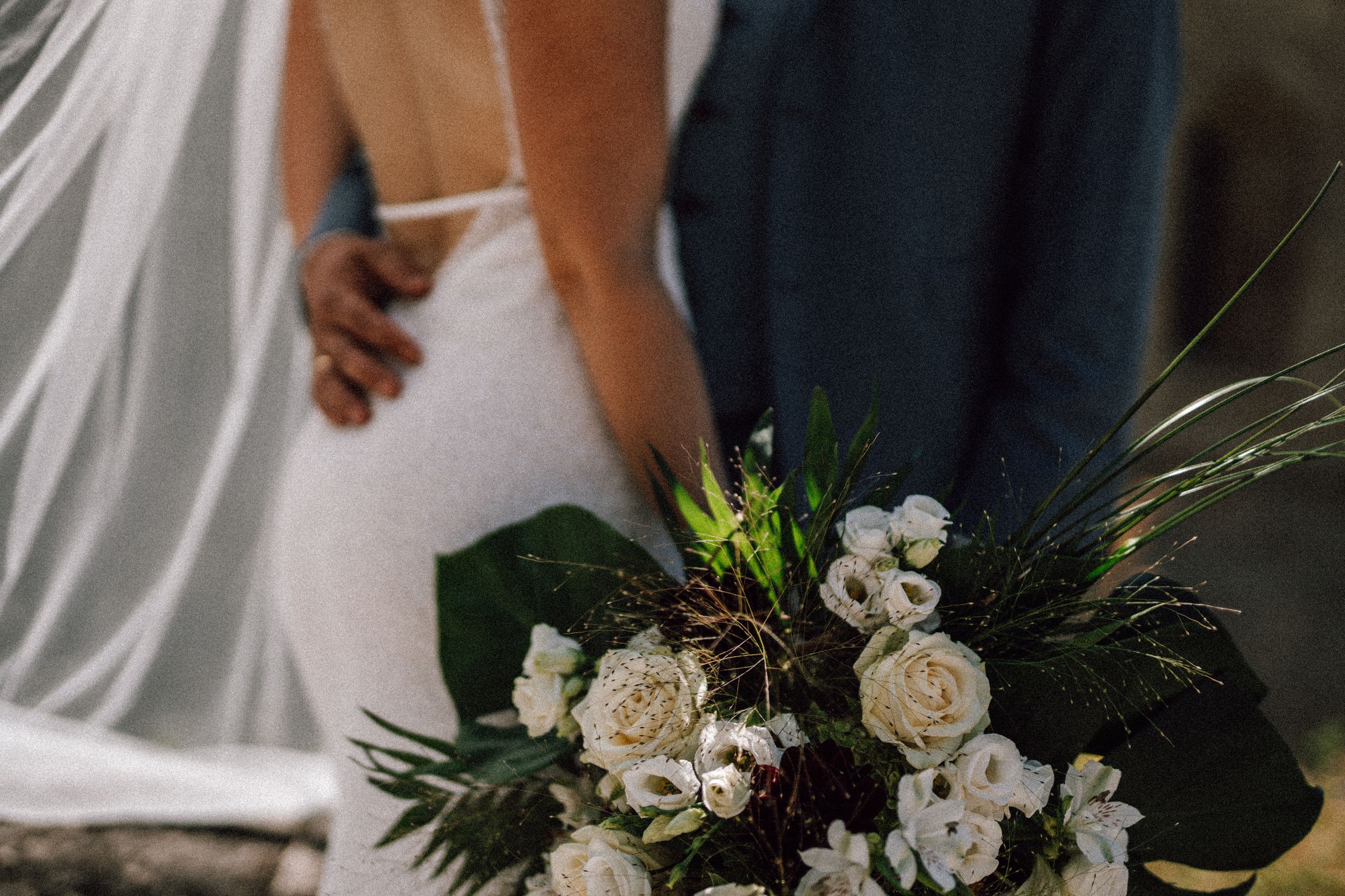 Wedding floral arrangements with white roses and greenery in natural light.