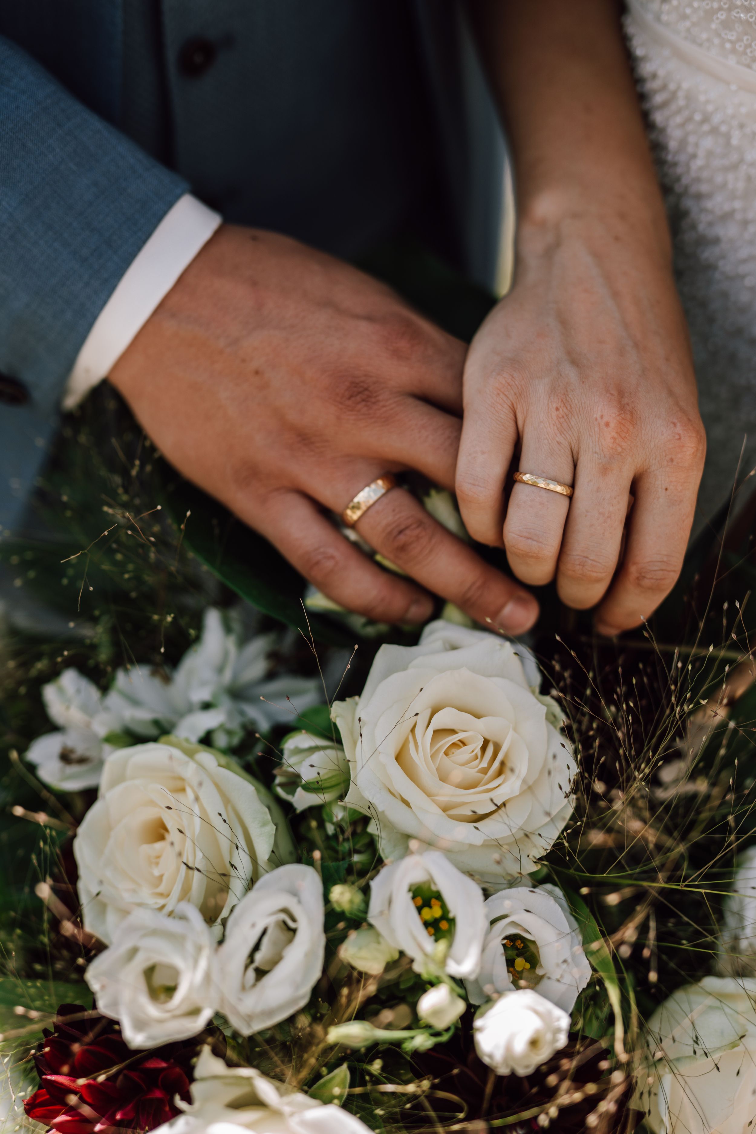 Wedding rings and white roses in an elegant bouquet arrangement.