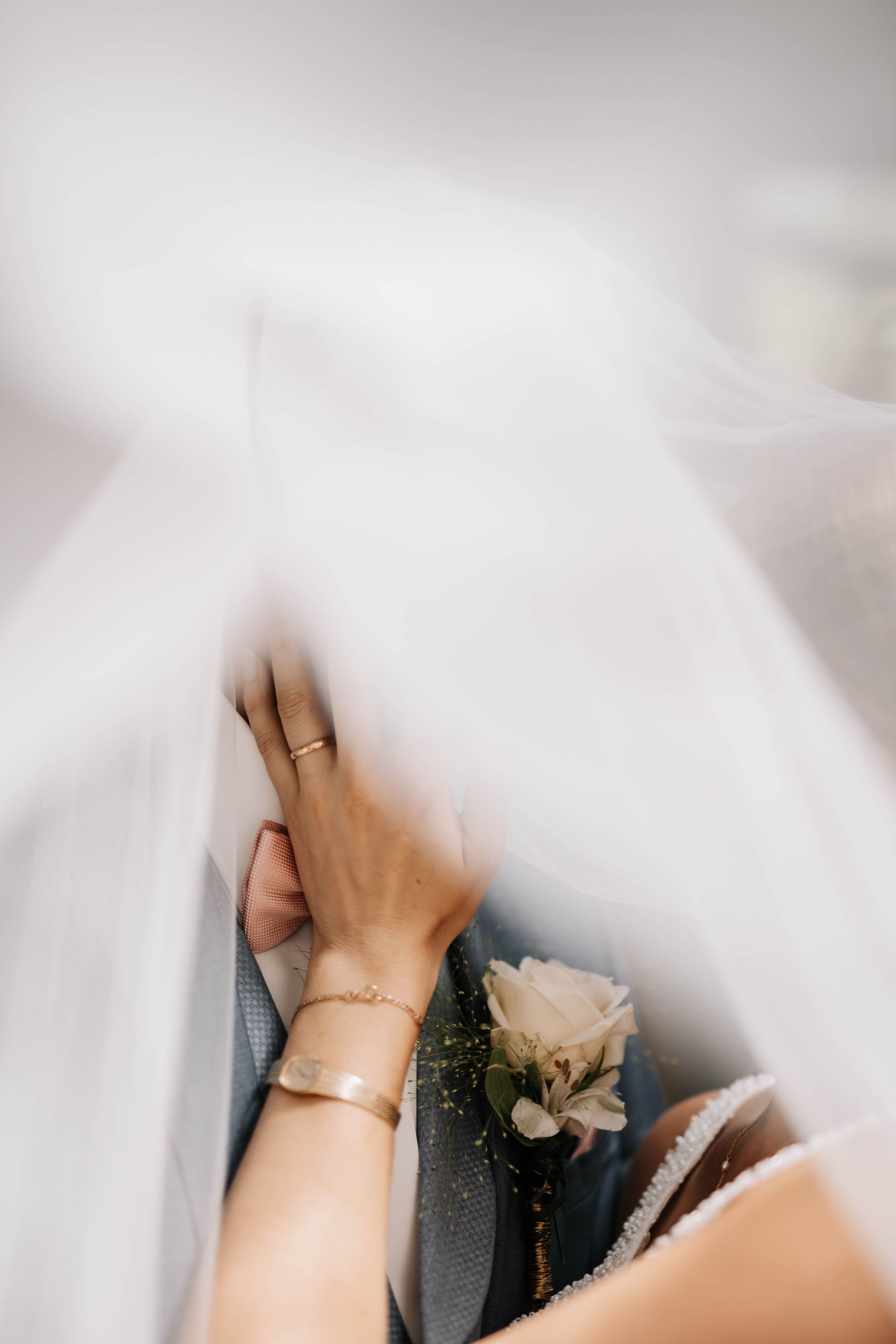 Tender moment captured through delicate white veil at wedding celebration.