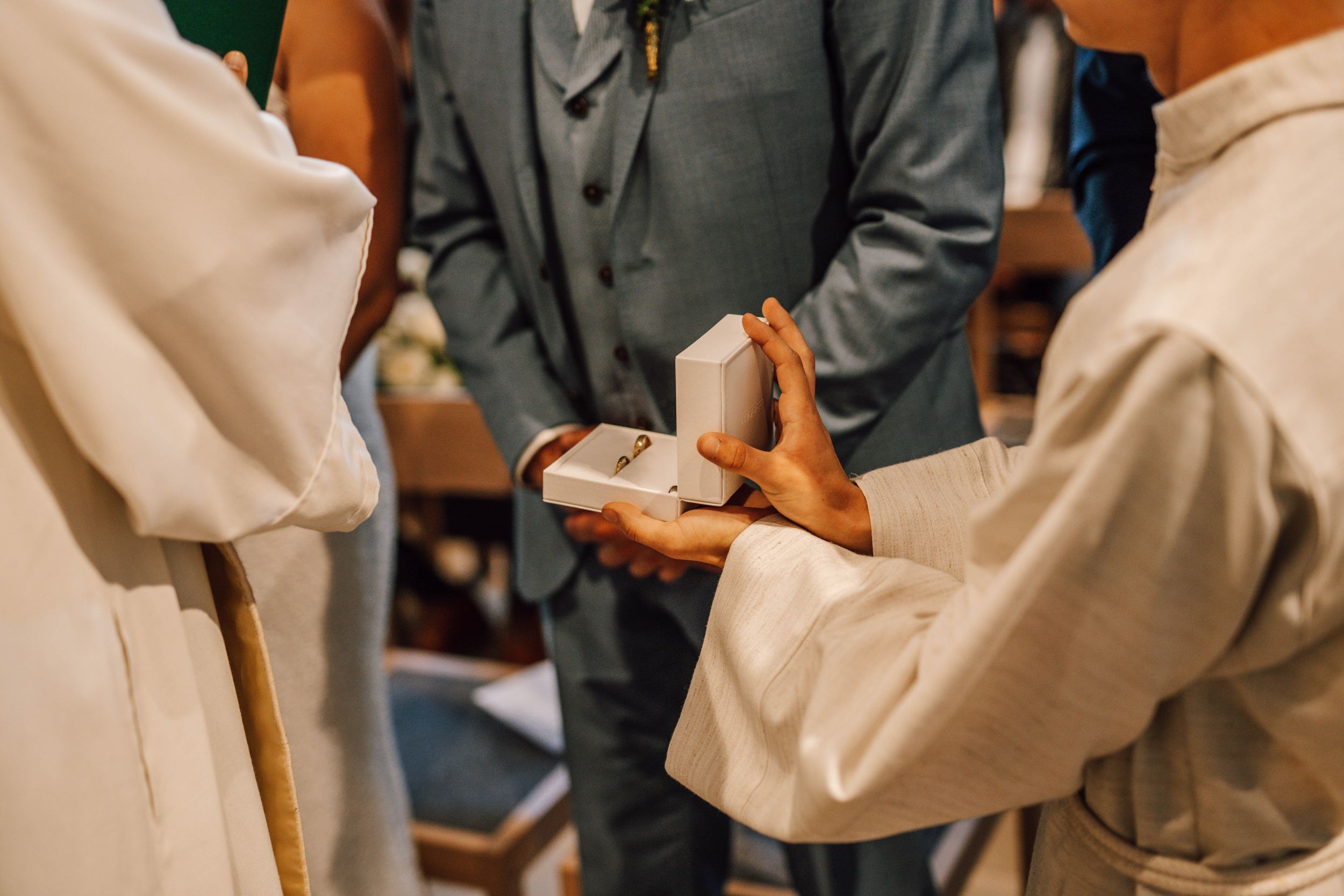 Close-up of hands exchanging rings during a wedding ceremony.