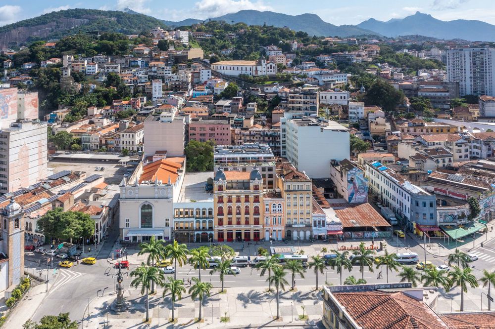 Aerial view of a coastal city with mountains, historic buildings and a golden domed church.
