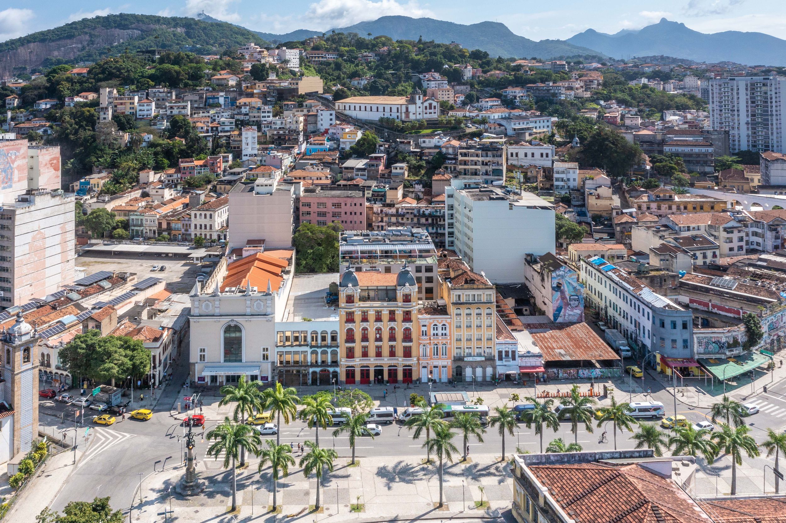 Aerial view of a coastal city with mountains, historic buildings and a golden domed church.