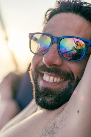 Close-up of colorful mirrored sunglasses reflecting sunset colors.