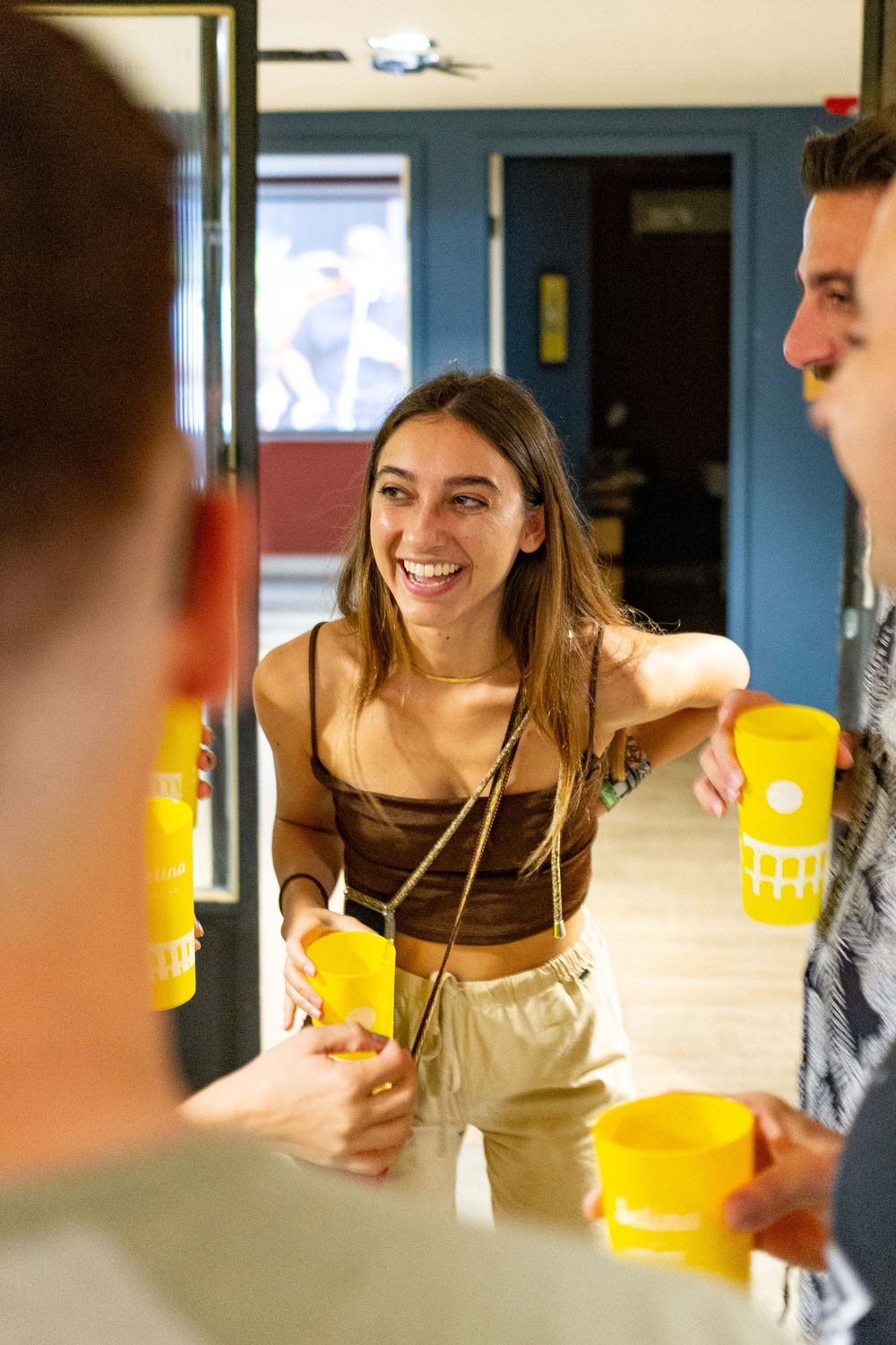 Social gathering with drinks in a hallway setting.