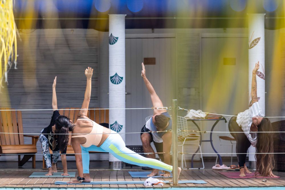 Yoga class practicing side plank poses in front of a studio window.