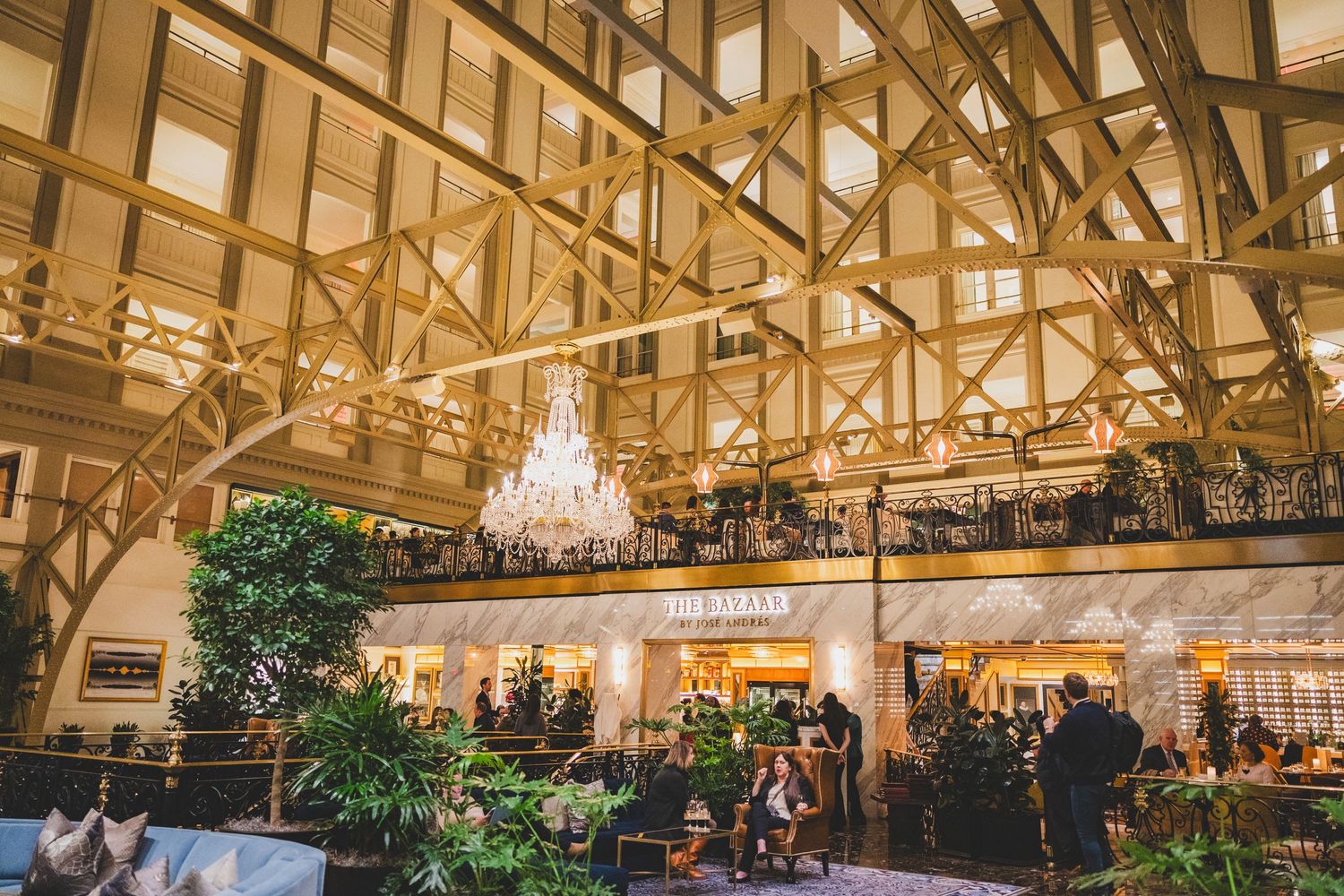 Restaurant interior with wooden beam architecture and crystal chandelier lighting.