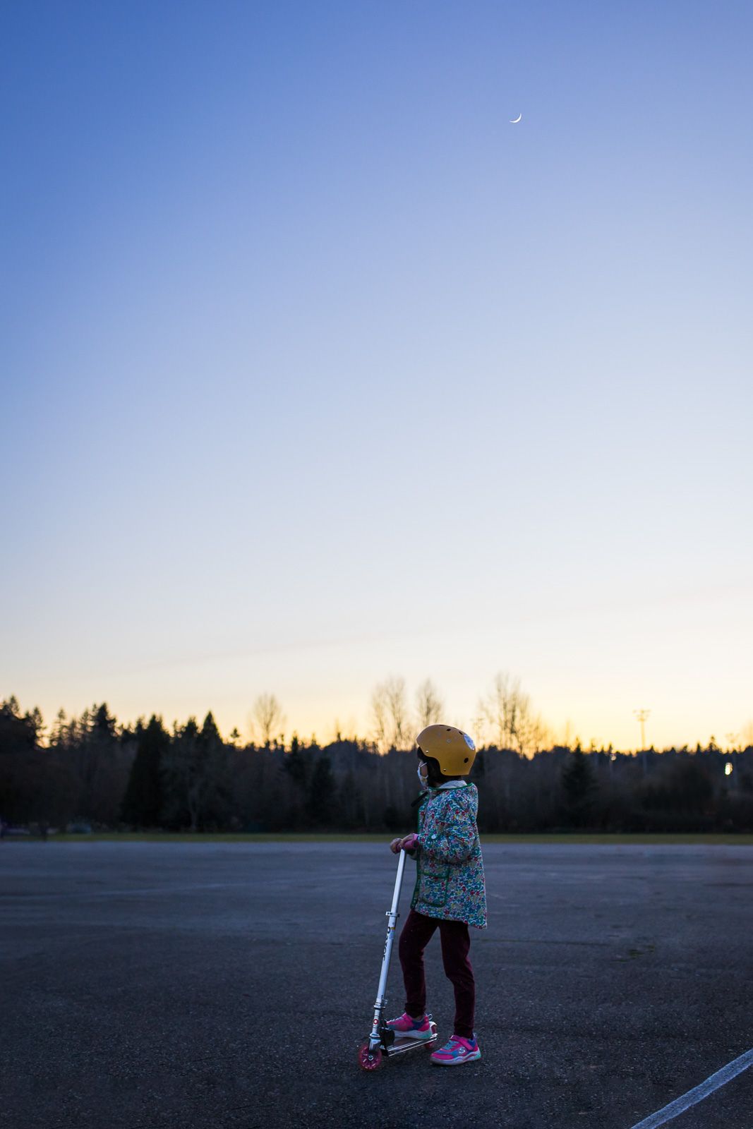 Daughter riding scooter and observing the night sky