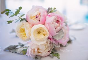 Delicate bouquet of pink and cream garden roses with soft green foliage.