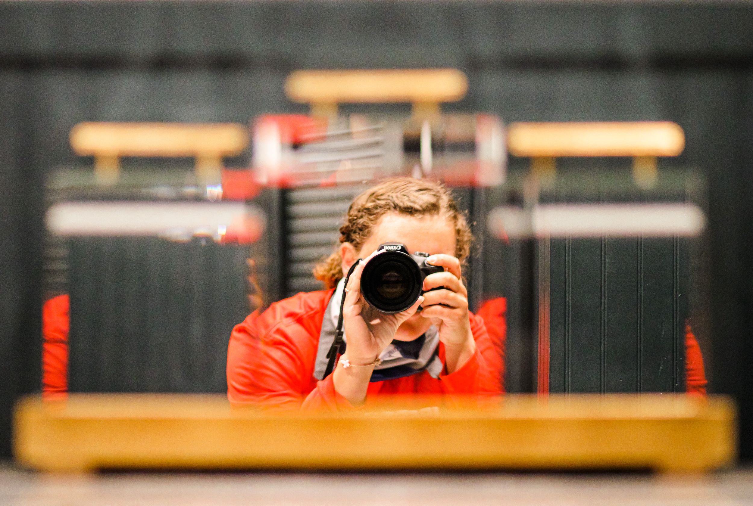 Creative self-portrait reflection of photographer in mirror with camera.