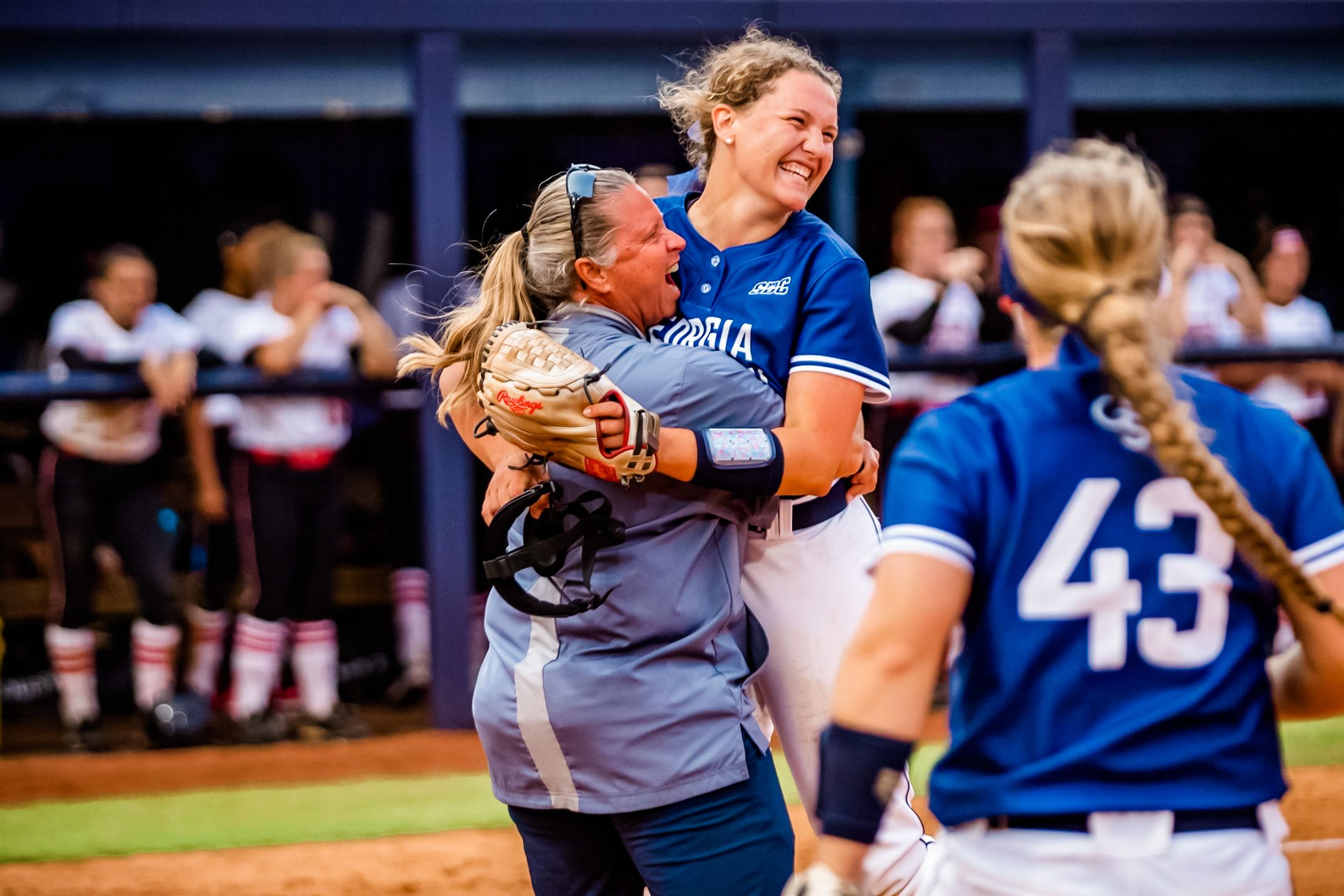 A softball player and coach embracing after a big win.