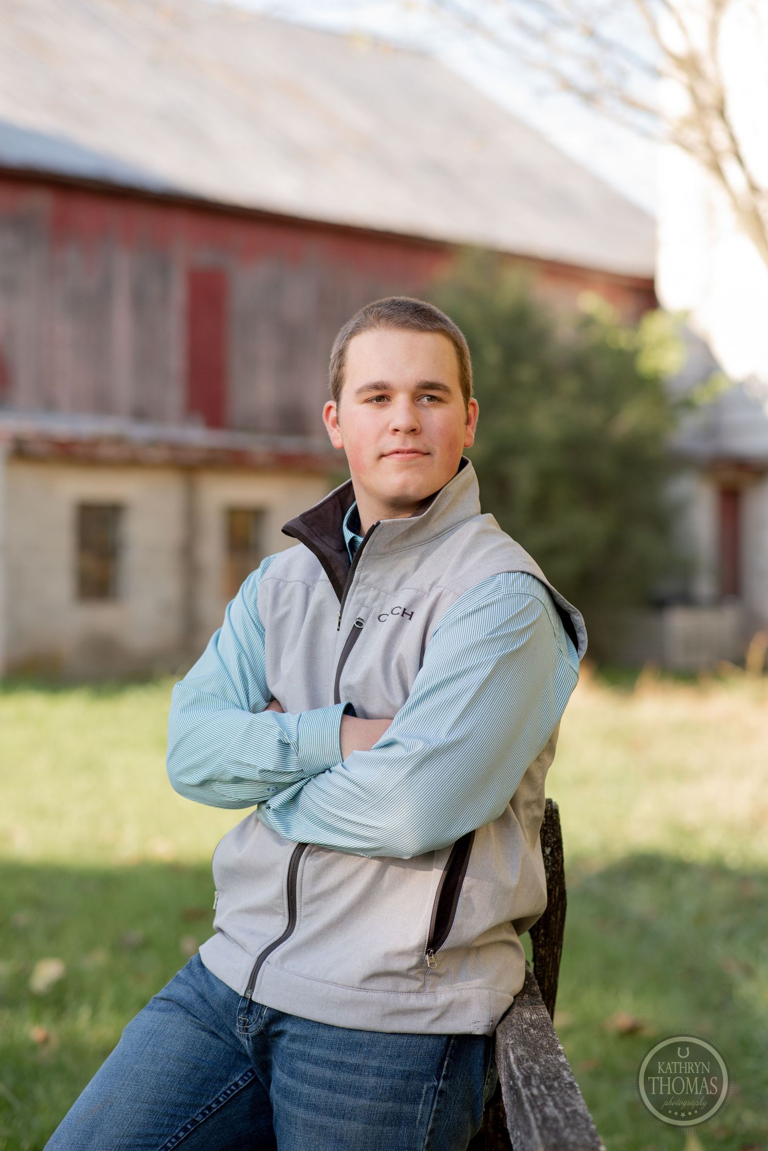 Person wearing two-tone vest leans against post in casual outdoor portrait.