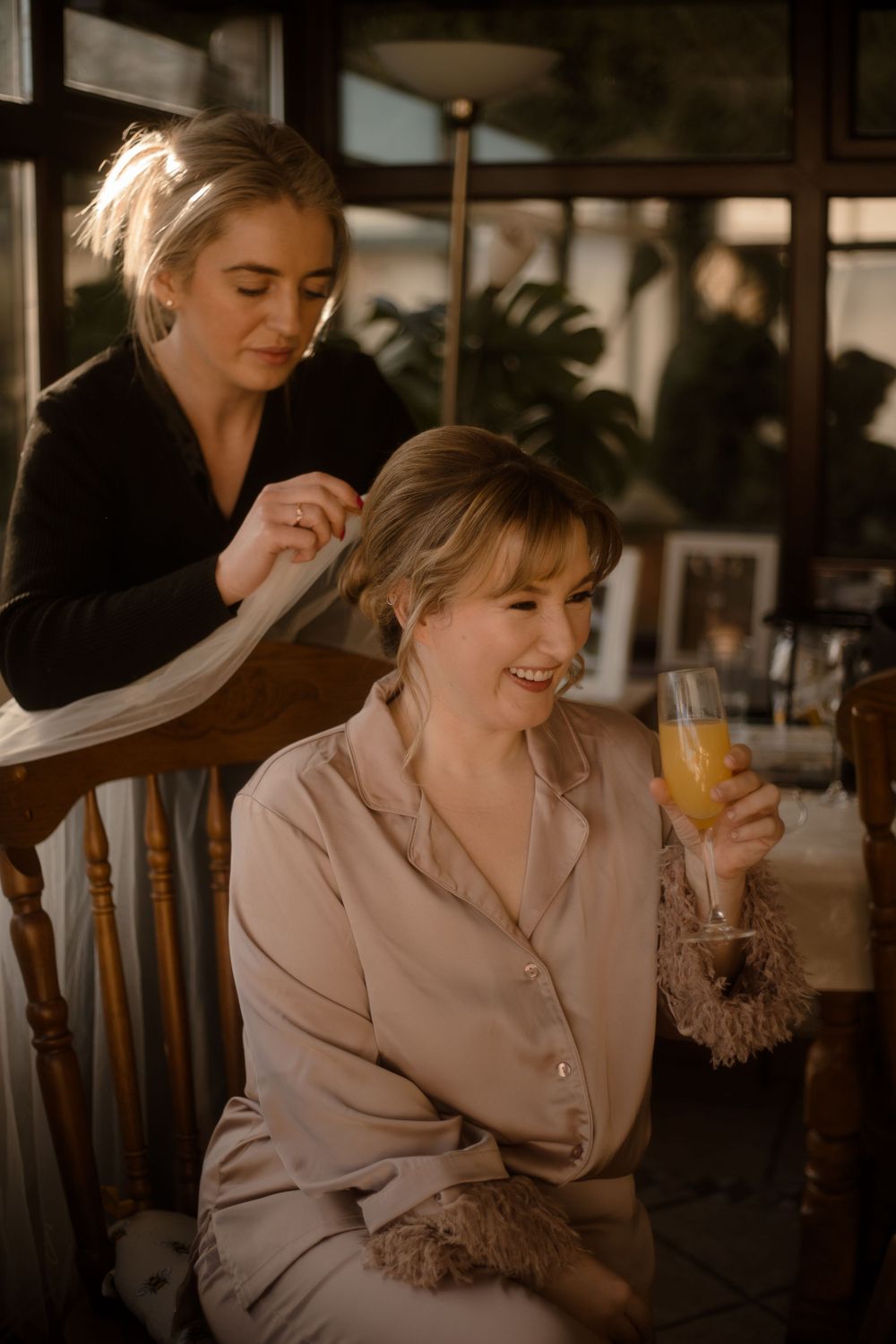 Getting ready scene with hair styling while enjoying morning mimosas.