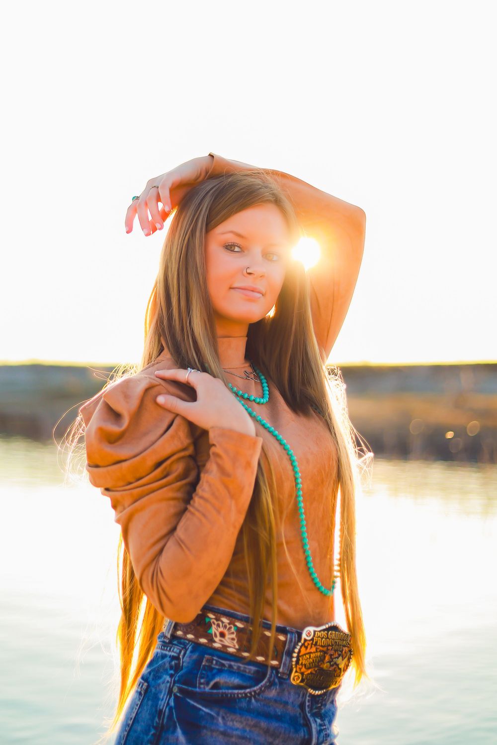Bohemian style portrait of woman in western wear posing at golden hour.