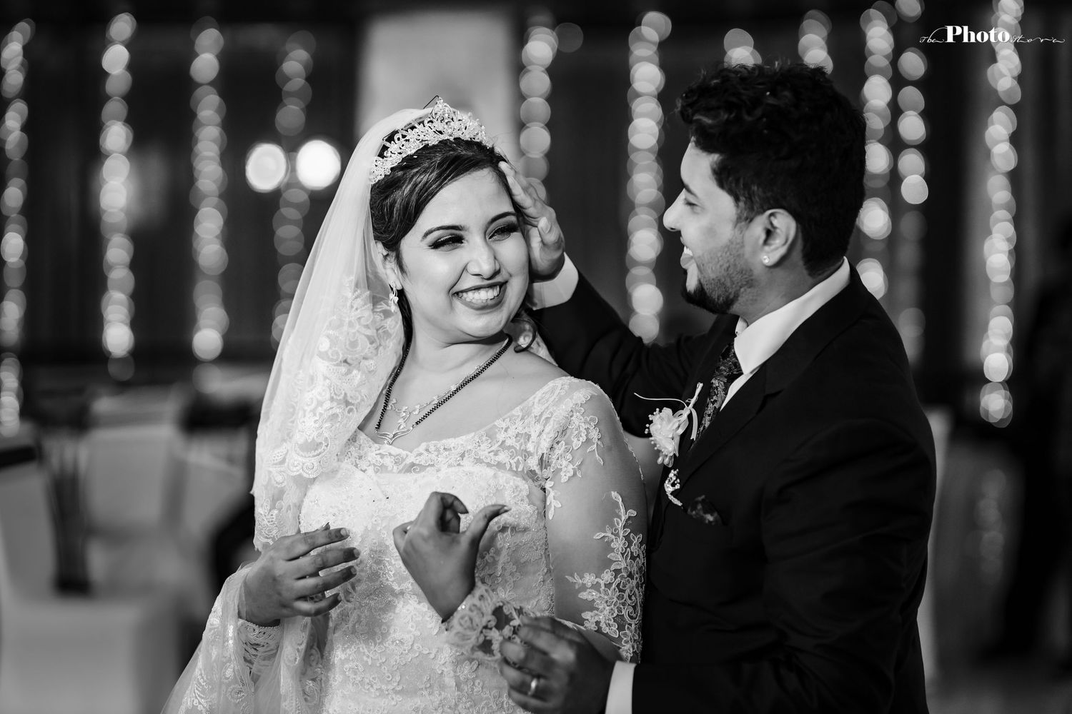 A black and white portrait of a couple sharing a tender moment at their wedding.