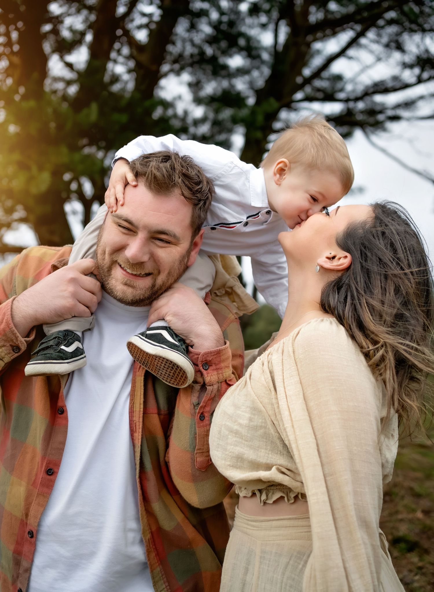 Parents holding their child, while watching a beautiful sunset in The New Forest, Lymington.