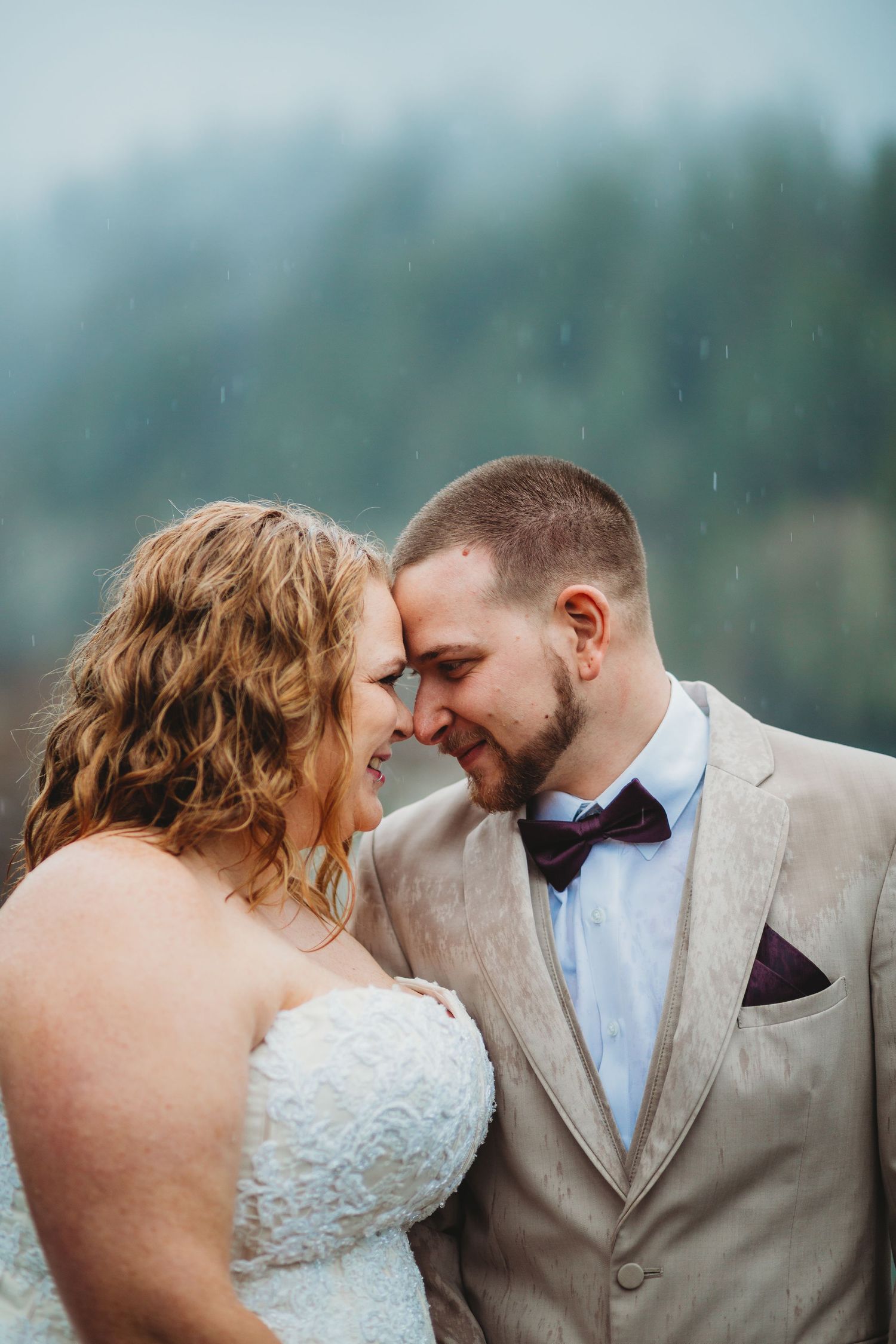 Forehead to forehead, a bride and groom smile at their elopement.