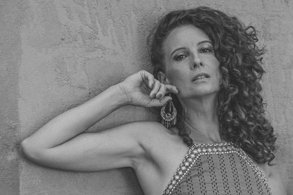 A black and white portrait showcasing curly hair and ornate jewellery. SIX84 Photography, Portrait Photography, Sydney