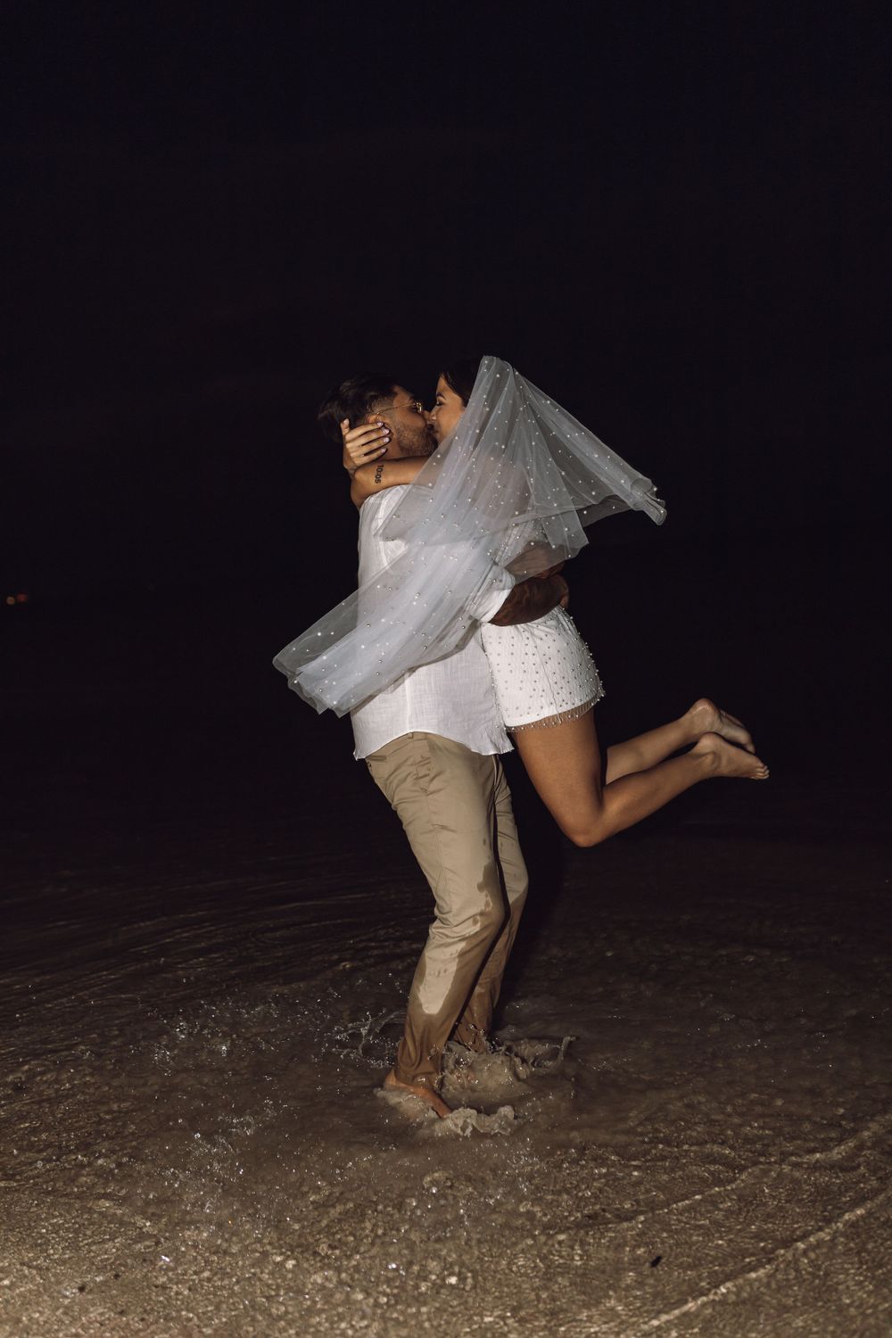 Beach elopement night photo with champagne bride and groom on the beach flash photography trash the dress