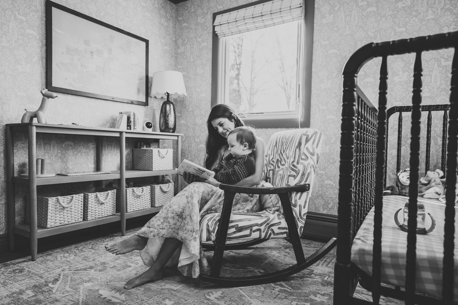 A black and white image of a vintage rocking chair beside a window in a rustic room setting in the Hudson Valley,NY.