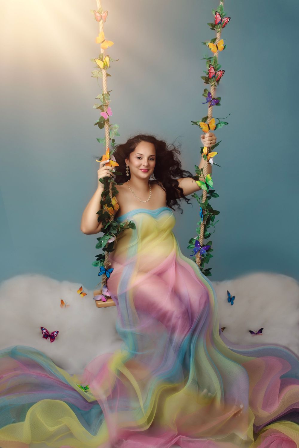 Whimsical portrait on butterfly-adorned swing with rainbow dress.