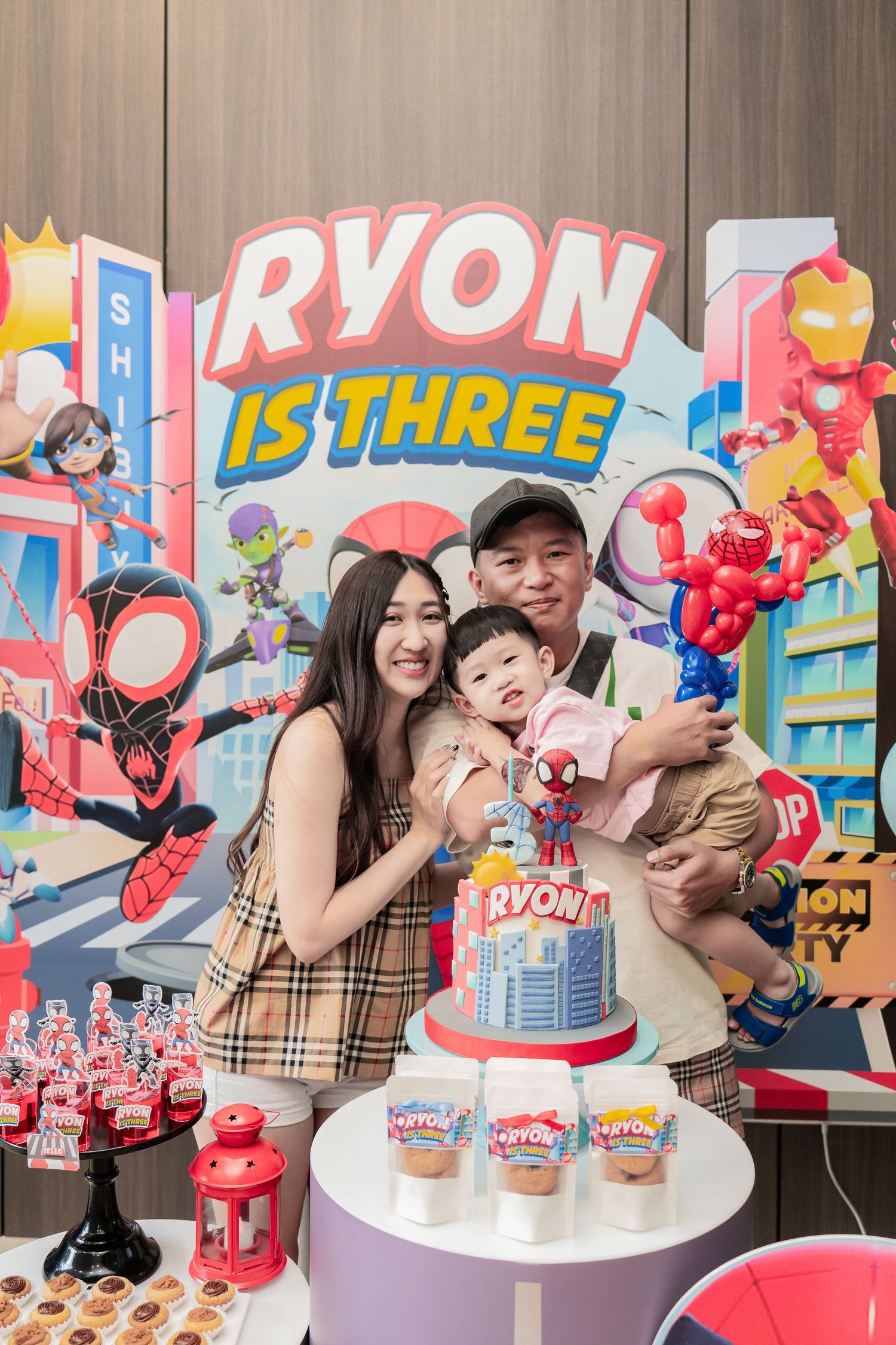 A festive superhero-themed third birthday party celebration with decorations and a custom cake.