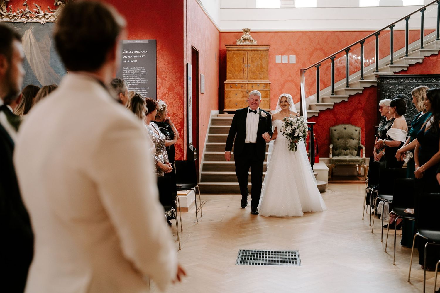 bride and groom walking down aisle to meet the groom in the European art gallery at the ashmolean museum