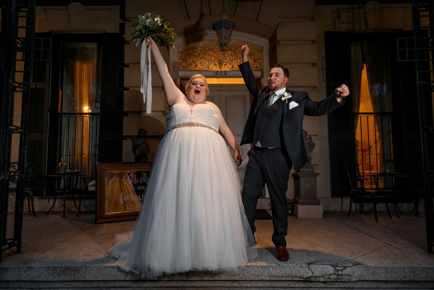 A joyful celebration moment captured outside a historic building during an evening wedding.