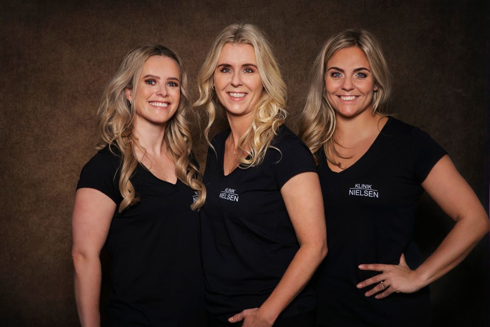 Teammedlemmer i sorte uniformer poserer sammen til et professionelt foto.