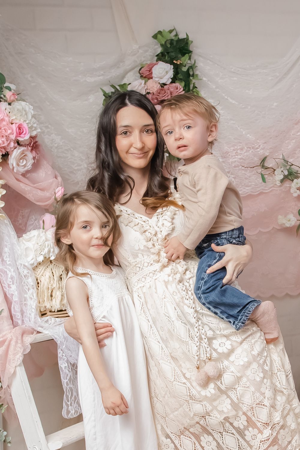 Elegant family portrait with floral backdrop and soft pink decor.